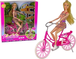 Bambola sulla bicicletta rosa