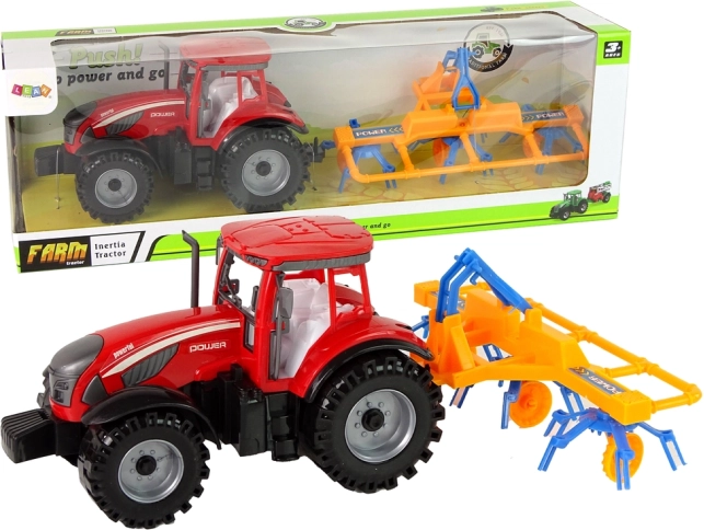 Trattore rosso con ranghinatore a trazione a frizione