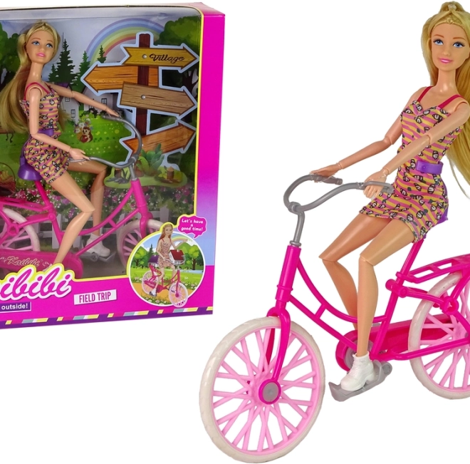 Bambola sulla bicicletta rosa
