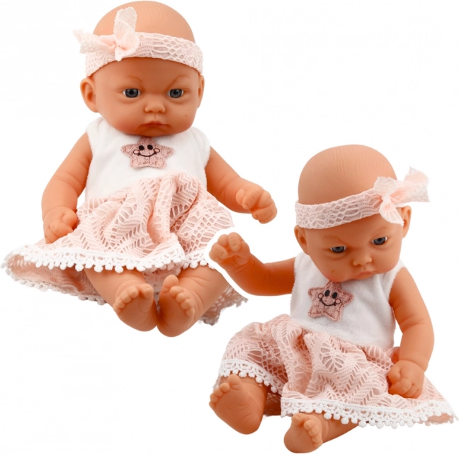 Bambola bebè in vestito rosa con cerchietto