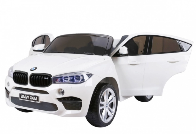 BMW X6M XXL pro 2 bambini Bianco + telecomando + eco pelle + cinture di sicurezza + partenza lenta + MP3 USB + LED