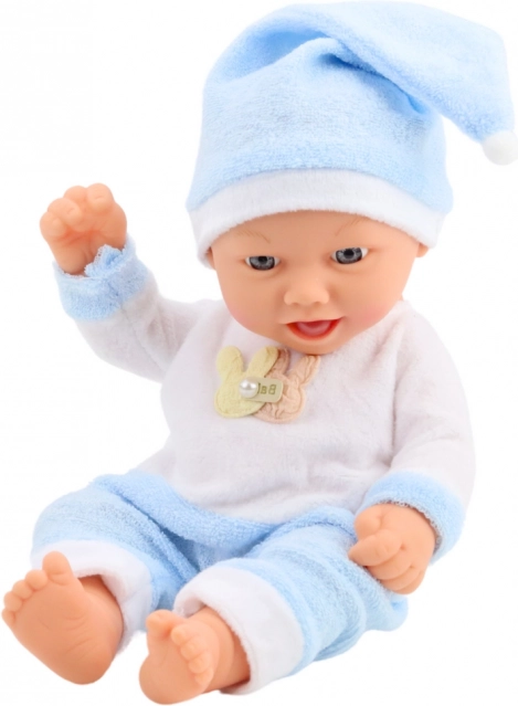Bambola di bambino in pigiama blu con cappellino con pon pon