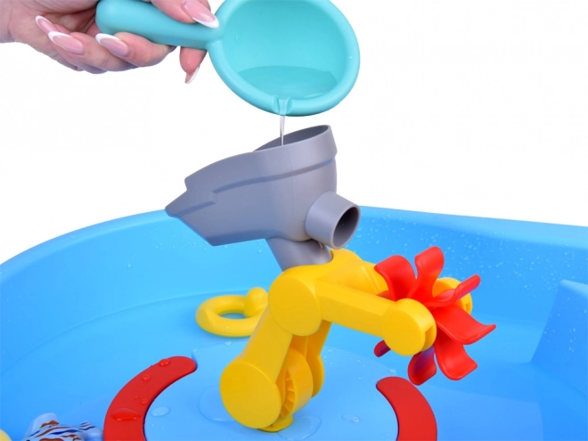 Tavolo d'acqua blu con mulino ad acqua e accessori da pesca