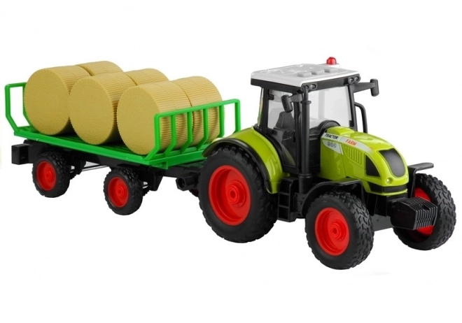 Trattore verde con rimorchio e fieno