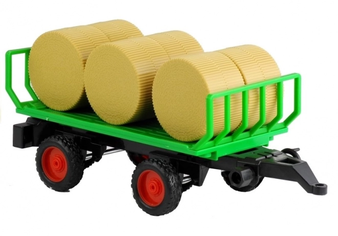 Trattore verde con rimorchio e fieno